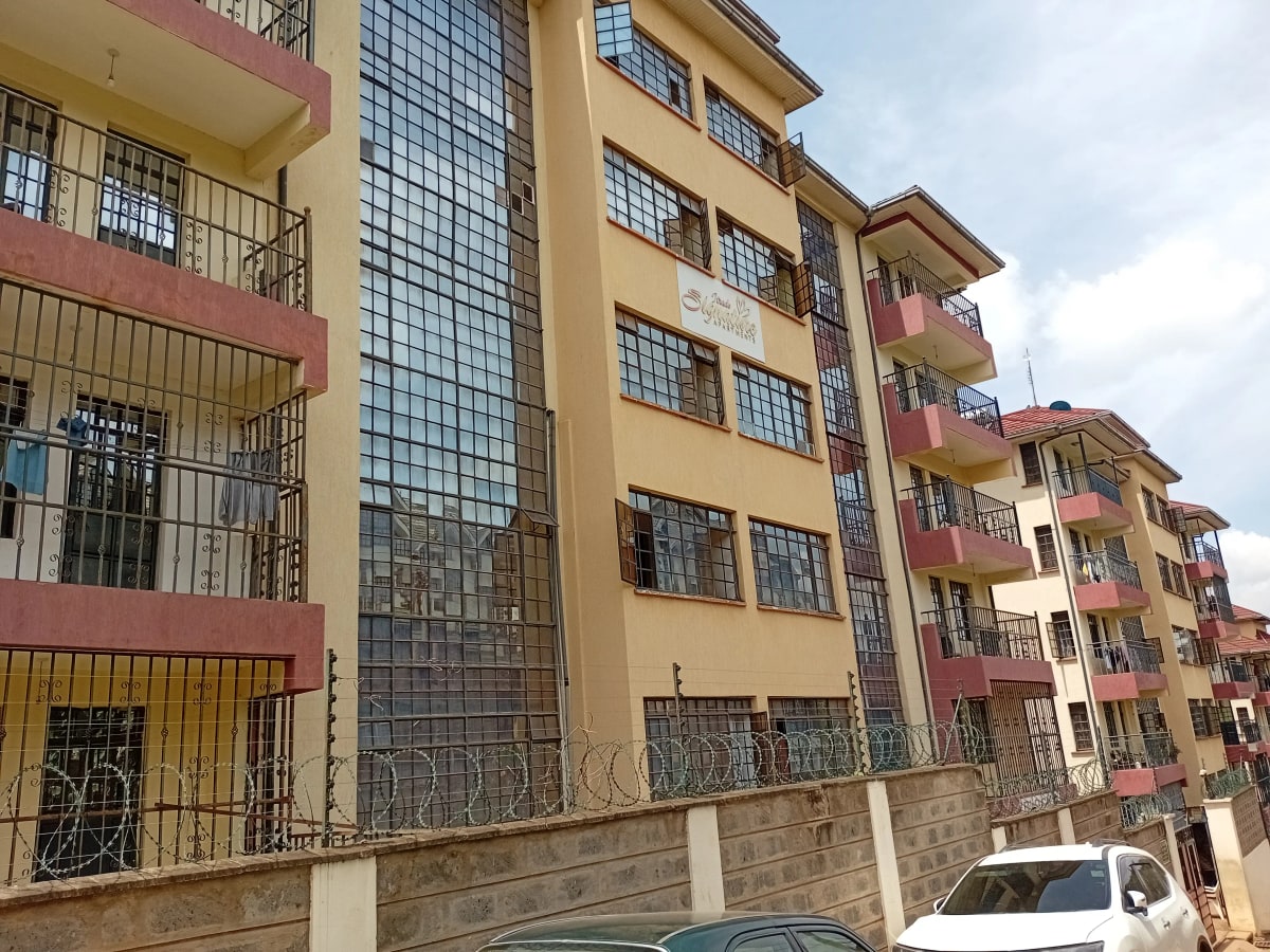 Multi-story residential building facade with balconies and parking