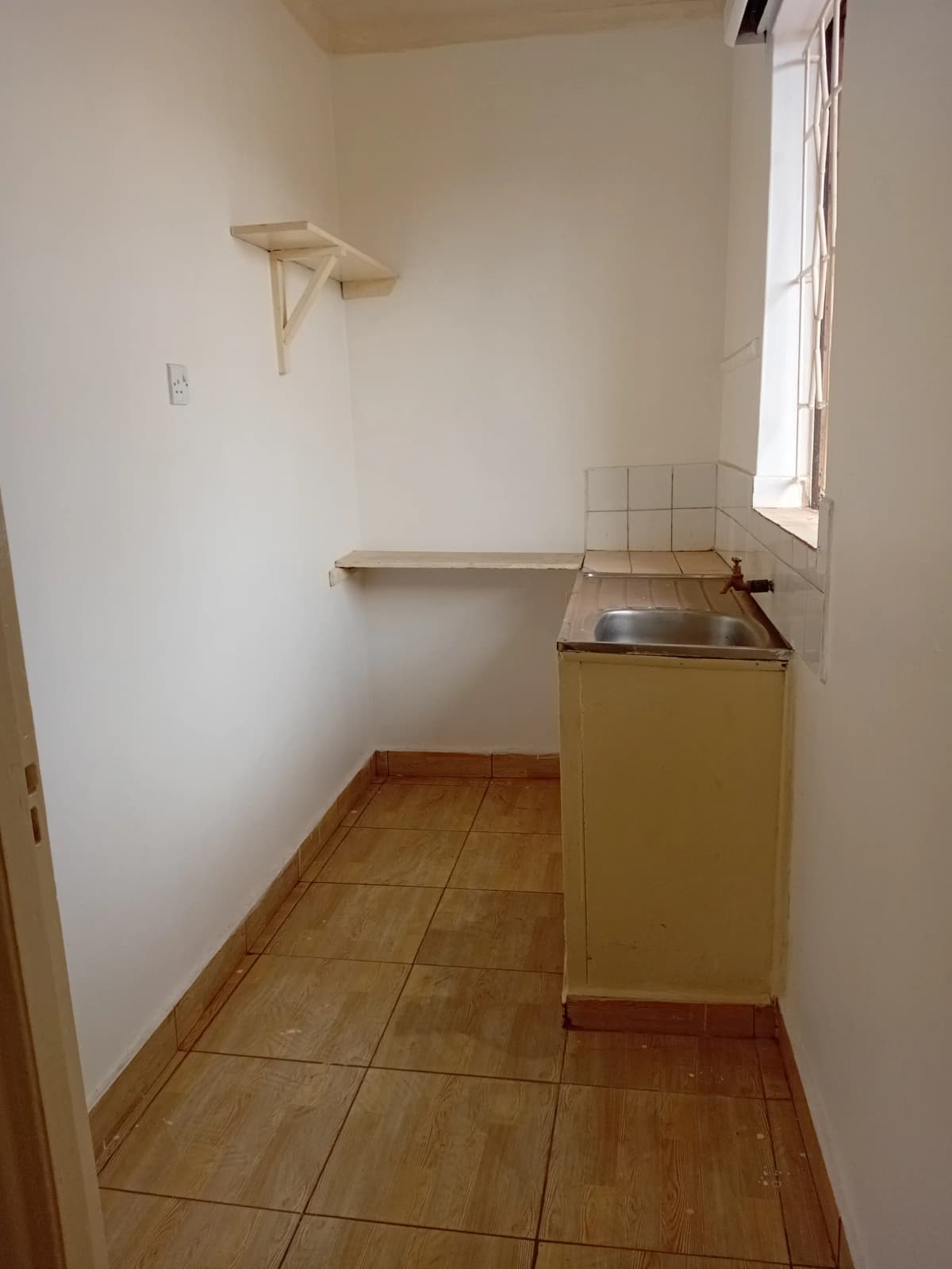 Compact kitchen with sink unit and wall shelving